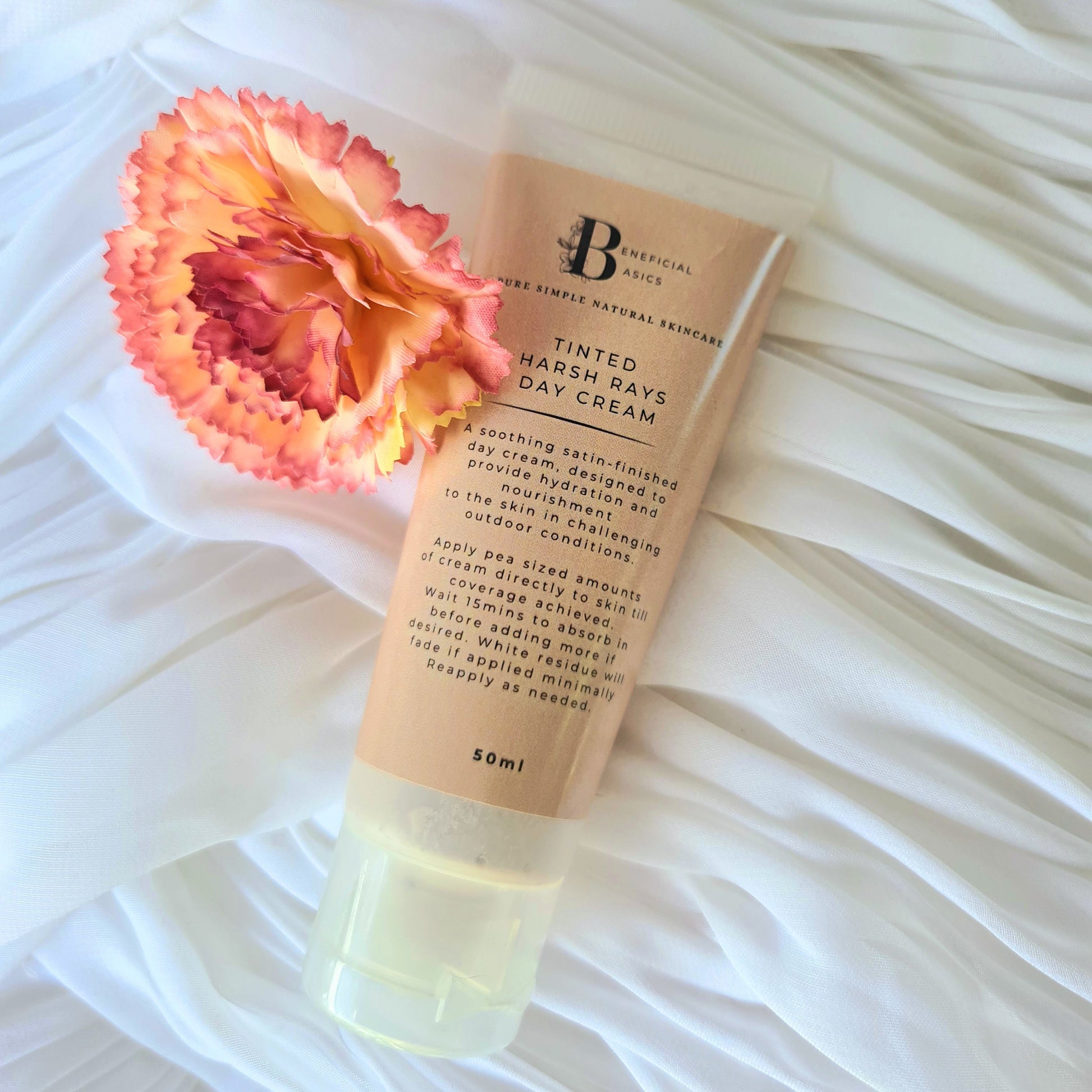 Tinted beef tallow hand and body cream with a pink flower on a white textured background