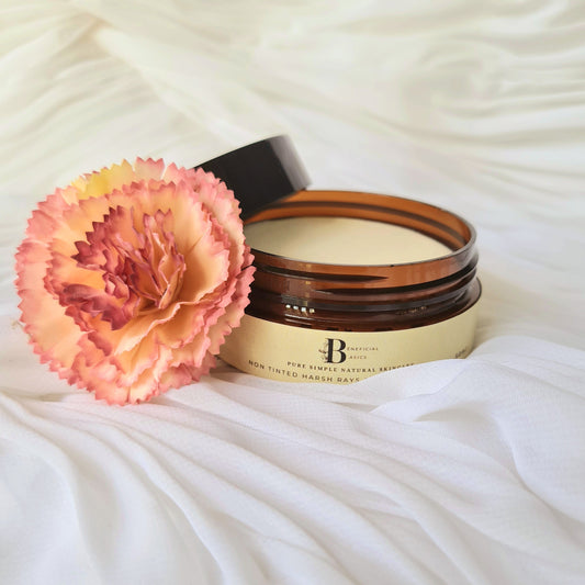 Jar of beef tallow zinc cream with a pink flower on a textured white surface