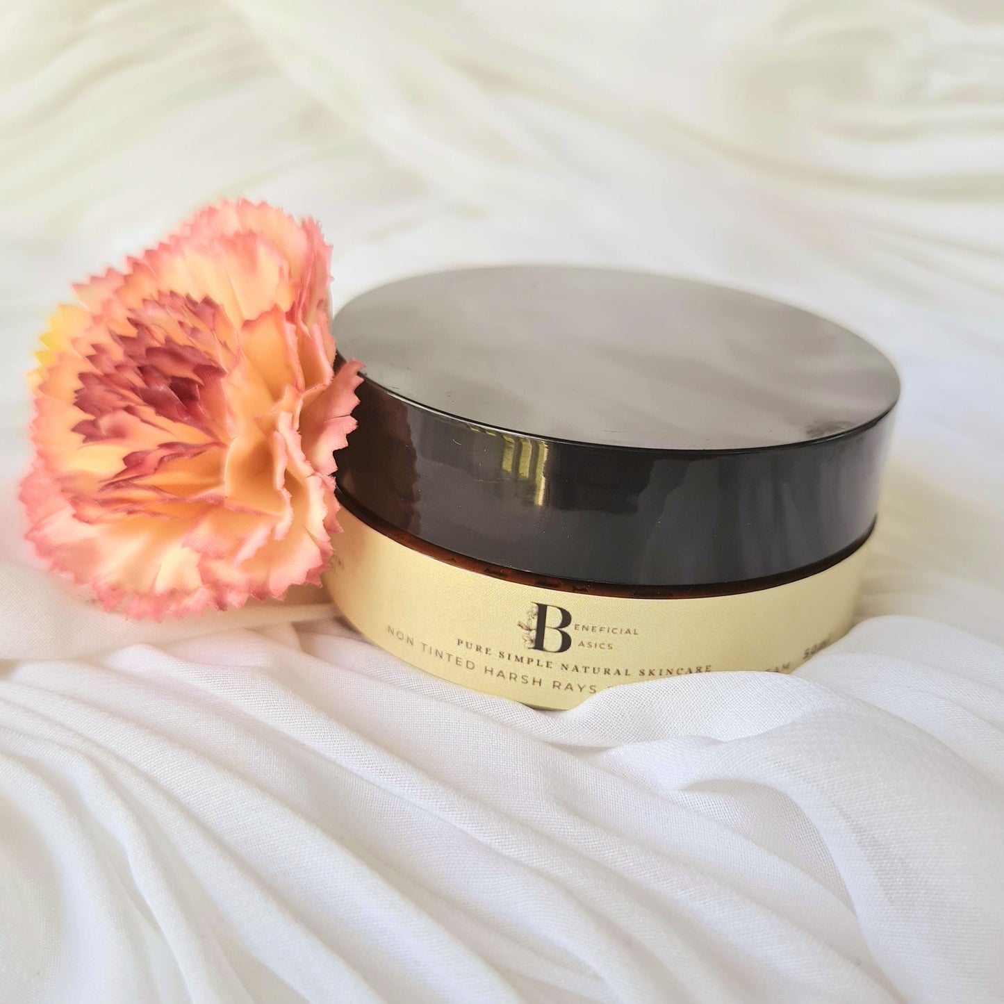 Cosmetic container with a pink flower on a white fabric background