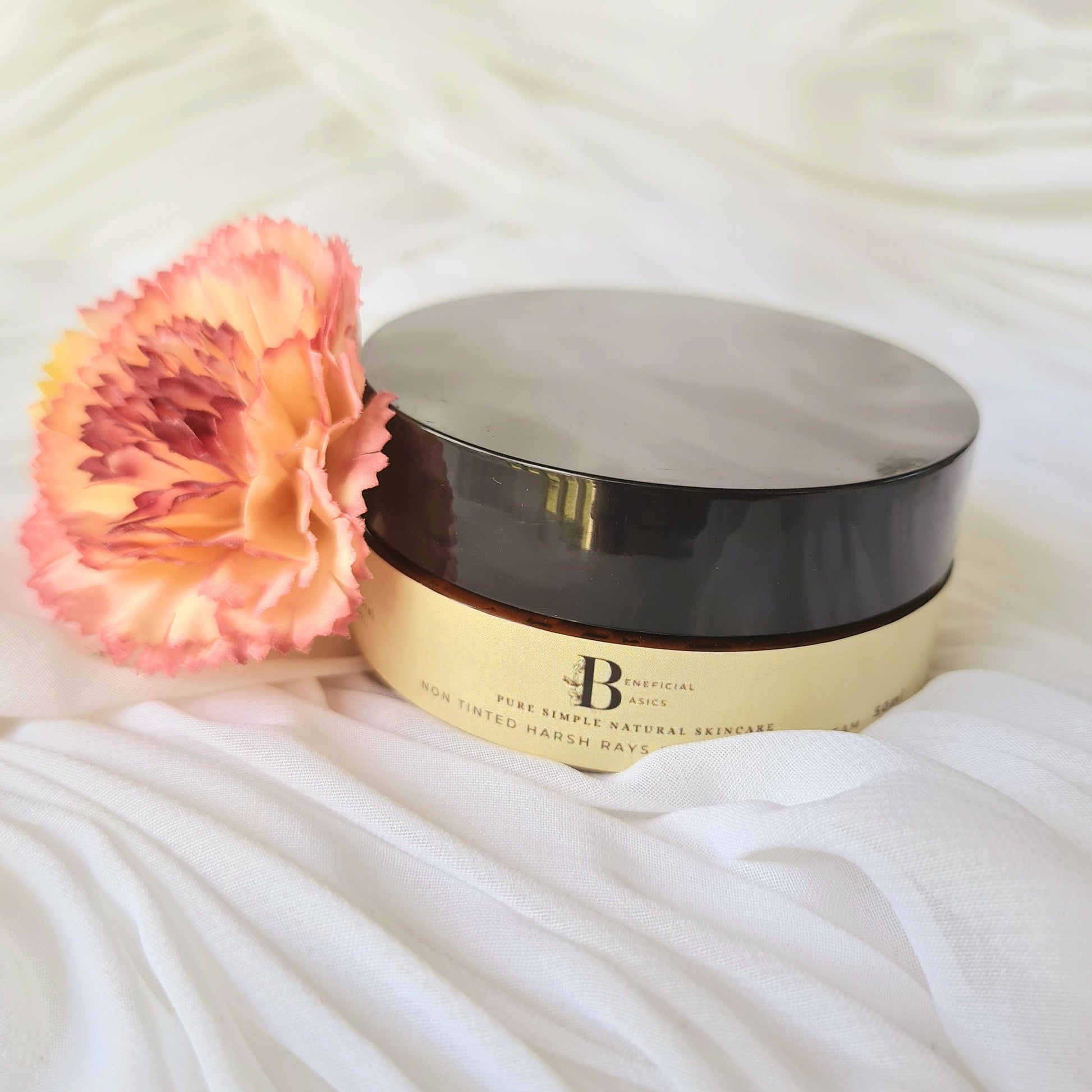 Cosmetic container with a pink flower on a white fabric background