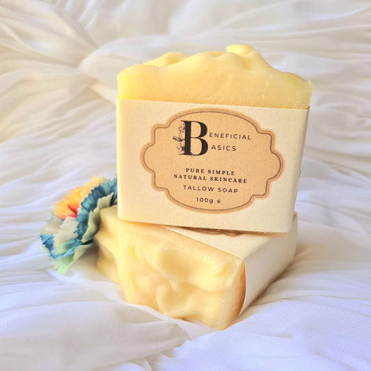 Bar of beef tallow soap with a visible brand label on a white textured background