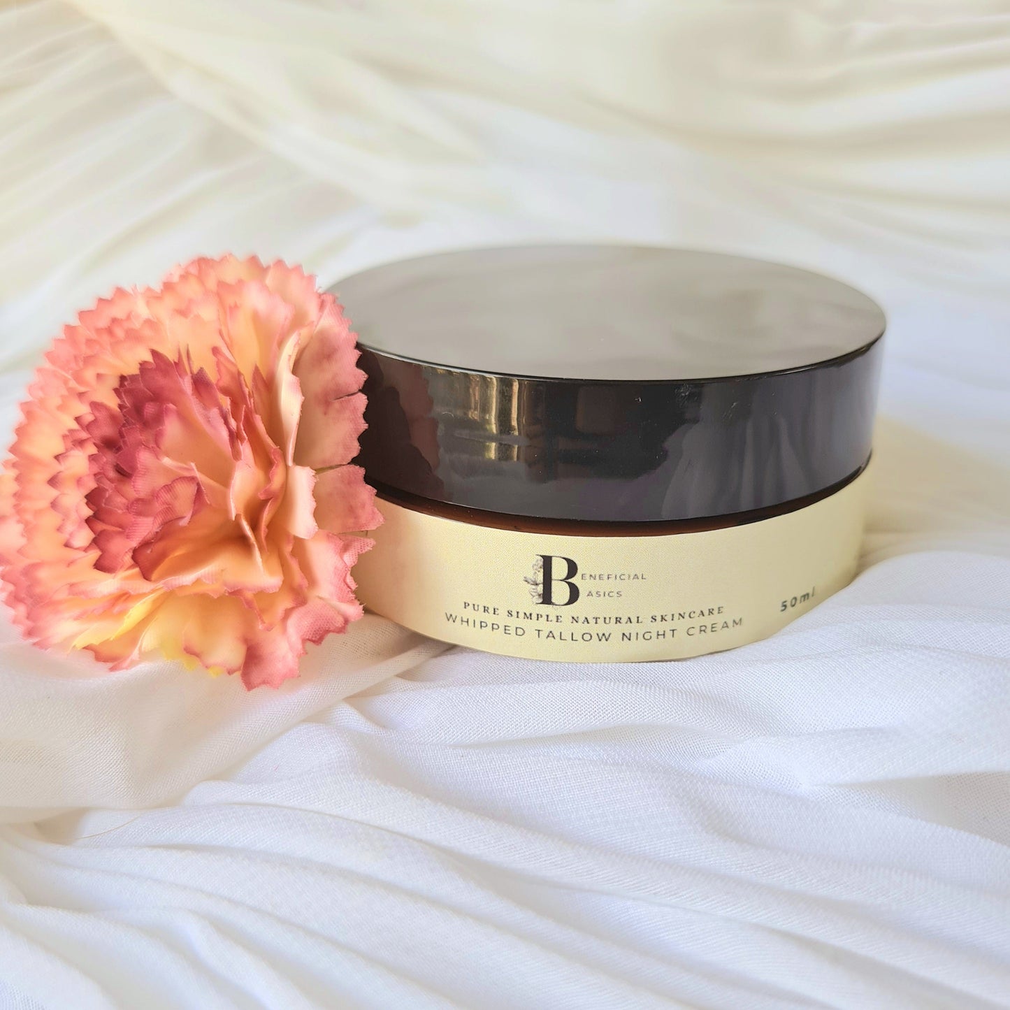 Cosmetic container with a pink flower on a white fabric background